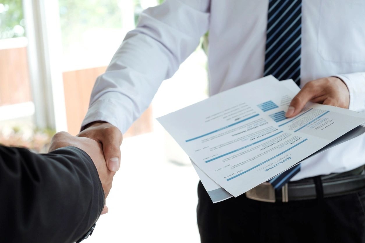Business professionals shaking hands with documents